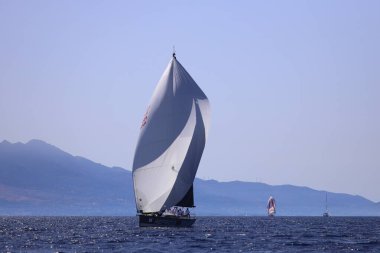 Bodrum, Hindi. 05 Ekim 2024: Ege Denizi 'nin mavi sularında, ünlü tatil beldesi Bodrum' un kıyılarında yelkenliler rüzgarlı havada yelken açıyor.