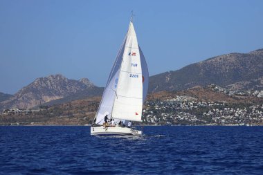 Bodrum, Hindi. 05 Ekim 2024: Ege Denizi 'nin mavi sularında, ünlü tatil beldesi Bodrum' un kıyılarında yelkenliler rüzgarlı havada yelken açıyor.