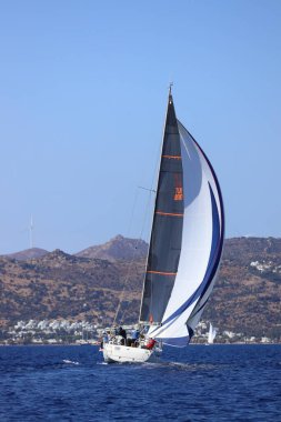 Bodrum, Hindi. 05 Ekim 2024: Ege Denizi 'nin mavi sularında, ünlü tatil beldesi Bodrum' un kıyılarında yelkenliler rüzgarlı havada yelken açıyor.