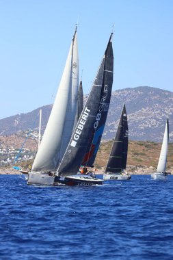 Bodrum, Hindi. 05 Ekim 2024: Ege Denizi 'nin mavi sularında, ünlü tatil beldesi Bodrum' un kıyılarında yelkenliler rüzgarlı havada yelken açıyor.