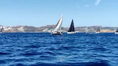 Bodrum, Hindi. 05 Ekim 2024: Ege Denizi 'nin mavi sularında, ünlü tatil beldesi Bodrum' un kıyılarında yelkenliler rüzgarlı havada yelken açıyor.