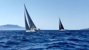 Bodrum, Hindi. 05 Ekim 2024: Ege Denizi 'nin mavi sularında, ünlü tatil beldesi Bodrum' un kıyılarında yelkenliler rüzgarlı havada yelken açıyor.