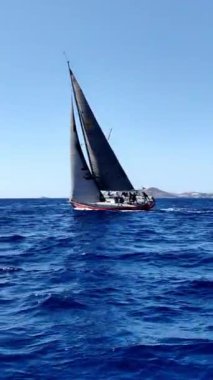 Bodrum, Hindi. 05 Ekim 2024: Yelkenliler Ege Denizi 'nin mavi sularında, ünlü tatil beldesi Bodrum' un kıyılarında rüzgarlı havada yelken açıyorlar. Sosyal medya için dikey video. 