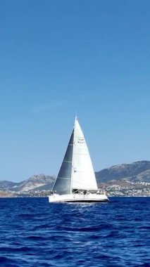 Bodrum, Hindi. 05 Ekim 2024: Yelkenliler Ege Denizi 'nin mavi sularında, ünlü tatil beldesi Bodrum' un kıyılarında rüzgarlı havada yelken açıyorlar. Sosyal medya için dikey video. 