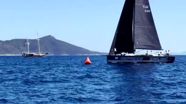 Bodrum, Hindi. 05 Ekim 2024: Ege Denizi 'nin mavi sularında, ünlü tatil beldesi Bodrum' un kıyılarında yelkenliler rüzgarlı havada yelken açıyor.