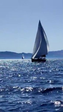 Bodrum, Hindi. 05 Ekim 2024: Yelkenliler Ege Denizi 'nin mavi sularında, ünlü tatil beldesi Bodrum' un kıyılarında rüzgarlı havada yelken açıyorlar. Sosyal medya için dikey video. 
