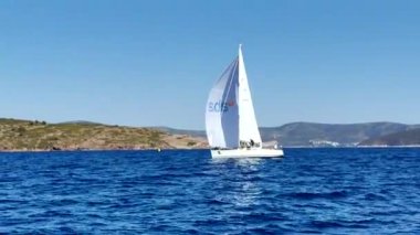 Bodrum, Hindi. 05 Ekim 2024: Ege Denizi 'nin mavi sularında, ünlü tatil beldesi Bodrum' un kıyılarında yelkenliler rüzgarlı havada yelken açıyor.
