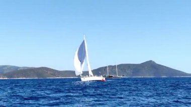 Bodrum, Hindi. 05 Ekim 2024: Ege Denizi 'nin mavi sularında, ünlü tatil beldesi Bodrum' un kıyılarında yelkenliler rüzgarlı havada yelken açıyor.