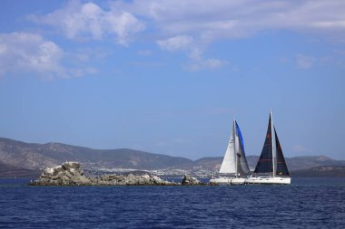 Bodrum, Hindi. 06 Ekim 2024: Yelkenliler Ege Denizi 'nin mavi sularında, ünlü tatil beldesi Bodrum' un kıyılarında rüzgarlı havada yelken açıyor.