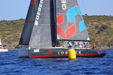 Bodrum, Hindi. 06 Ekim 2024: Yelkenliler Ege Denizi 'nin mavi sularında, ünlü tatil beldesi Bodrum' un kıyılarında rüzgarlı havada yelken açıyor.