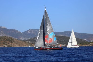 Bodrum, Hindi. 06 Ekim 2024: Yelkenliler Ege Denizi 'nin mavi sularında, ünlü tatil beldesi Bodrum' un kıyılarında rüzgarlı havada yelken açıyor.