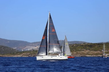 Bodrum, Hindi. 06 Ekim 2024: Yelkenliler Ege Denizi 'nin mavi sularında, ünlü tatil beldesi Bodrum' un kıyılarında rüzgarlı havada yelken açıyor.