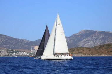 Bodrum, Hindi. 06 Ekim 2024: Yelkenliler Ege Denizi 'nin mavi sularında, ünlü tatil beldesi Bodrum' un kıyılarında rüzgarlı havada yelken açıyor.