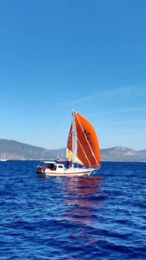 Bodrum, Hindi. 06 Ekim 2024: Yelkenliler Ege Denizi 'nin mavi sularında, ünlü tatil beldesi Bodrum' un kıyılarında rüzgarlı havada yelken açıyorlar. Sosyal medya için dikey video.  