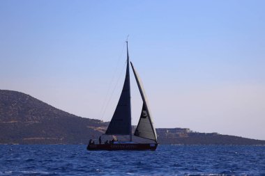 Bodrum, Hindi. 19 Ekim 2024: Yelkenliler Ege Denizi 'nin mavi sularında, ünlü tatil beldesi Bodrum' un kıyılarında rüzgarlı havada yelken açıyorlar..