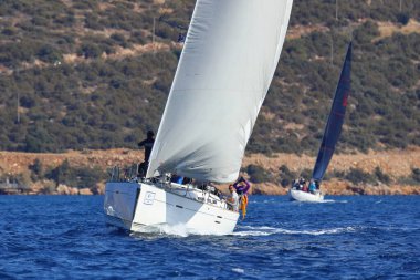 Bodrum, Hindi. 19 Ekim 2024: Yelkenliler Ege Denizi 'nin mavi sularında, ünlü tatil beldesi Bodrum' un kıyılarında rüzgarlı havada yelken açıyorlar..