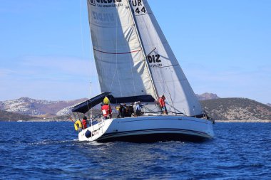 Bodrum, Hindi. 19 Ekim 2024: Yelkenliler Ege Denizi 'nin mavi sularında, ünlü tatil beldesi Bodrum' un kıyılarında rüzgarlı havada yelken açıyorlar..