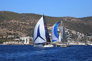 Bodrum, Hindi. 19 Ekim 2024: Yelkenliler Ege Denizi 'nin mavi sularında, ünlü tatil beldesi Bodrum' un kıyılarında rüzgarlı havada yelken açıyorlar..