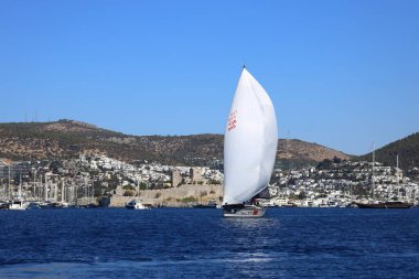 Bodrum, Hindi. 19 Ekim 2024: Yelkenliler Ege Denizi 'nin mavi sularında, ünlü tatil beldesi Bodrum' un kıyılarında rüzgarlı havada yelken açıyorlar..