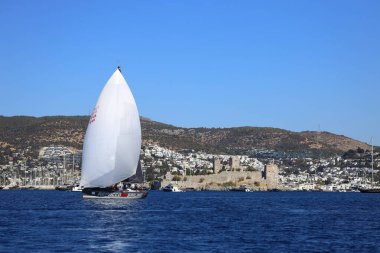 Bodrum, Hindi. 19 Ekim 2024: Yelkenliler Ege Denizi 'nin mavi sularında, ünlü tatil beldesi Bodrum' un kıyılarında rüzgarlı havada yelken açıyorlar..