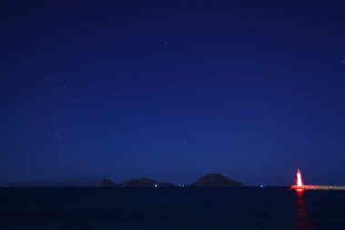 Güzel sahil manzaralı kuyruklu yıldız Tsuchinshan Atlas C2023 A3 ve Mavi Deniz. Turgutreis, Bodrum, Türkiye.