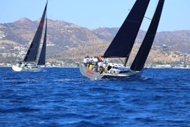 Bodrum, Hindi. 19 Ekim 2024: Yelkenliler Ege Denizi 'nin mavi sularında, ünlü tatil beldesi Bodrum' un kıyılarında rüzgarlı havada yelken açıyorlar..