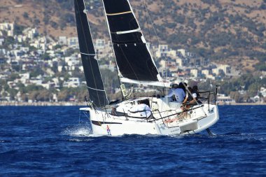 Bodrum, Hindi. 19 Ekim 2024: Yelkenliler Ege Denizi 'nin mavi sularında, ünlü tatil beldesi Bodrum' un kıyılarında rüzgarlı havada yelken açıyorlar..