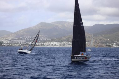 Bodrum, Hindi. 23 Kasım 2024: Yelkenliler Ege Denizi 'nin mavi sularında, ünlü tatil beldesi Bodrum' un kıyılarında rüzgarlı havada yelken açıyorlar..