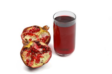 Taze sıkılmış nar suyu bardakta şeffaf bir şişe, kırık nar tohumu ve siyah düz bir taş tabakta siyah ahşap arka plan manzarası.