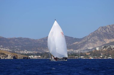 Bodrum, Hindi. 19 Ekim 2024: Yelkenliler Ege Denizi 'nin mavi sularında, ünlü tatil beldesi Bodrum' un kıyılarında rüzgarlı havada yelken açıyorlar..