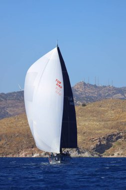 Bodrum, Hindi. 19 Ekim 2024: Yelkenliler Ege Denizi 'nin mavi sularında, ünlü tatil beldesi Bodrum' un kıyılarında rüzgarlı havada yelken açıyorlar..