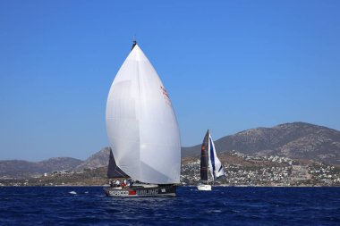 Bodrum, Hindi. 19 Ekim 2024: Yelkenliler Ege Denizi 'nin mavi sularında, ünlü tatil beldesi Bodrum' un kıyılarında rüzgarlı havada yelken açıyorlar..