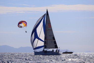 Bodrum, Hindi. 19 Ekim 2024: Yelkenliler Ege Denizi 'nin mavi sularında, ünlü tatil beldesi Bodrum' un kıyılarında rüzgarlı havada yelken açıyorlar..