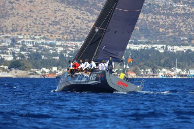 Bodrum, Hindi. 19 Ekim 2024: Yelkenliler Ege Denizi 'nin mavi sularında, ünlü tatil beldesi Bodrum' un kıyılarında rüzgarlı havada yelken açıyorlar..