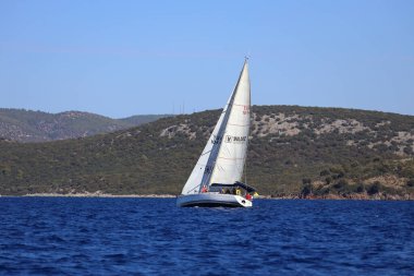 Bodrum, Hindi. 19 Ekim 2024: Yelkenliler Ege Denizi 'nin mavi sularında, ünlü tatil beldesi Bodrum' un kıyılarında rüzgarlı havada yelken açıyorlar..
