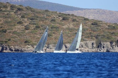 Bodrum, Hindi. 19 Ekim 2024: Yelkenliler Ege Denizi 'nin mavi sularında, ünlü tatil beldesi Bodrum' un kıyılarında rüzgarlı havada yelken açıyorlar..
