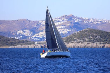 Bodrum, Hindi. 14 Aralık 2024: Yelkenliler Ege Denizi 'nin mavi sularında, ünlü tatil beldesi Bodrum' un kıyılarında rüzgarlı havada yelken açıyorlar..