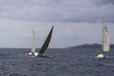 Bodrum, Hindi. 15 Aralık 2024: Yelkenliler Ege Denizi 'nin mavi sularında, ünlü tatil beldesi Bodrum' un kıyılarında rüzgarlı havada yelken açıyorlar..