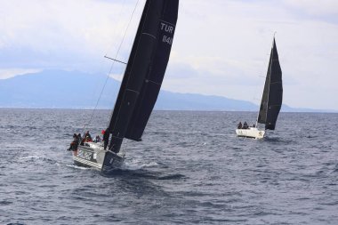 Bodrum, Hindi. 15 Aralık 2024: Yelkenliler Ege Denizi 'nin mavi sularında, ünlü tatil beldesi Bodrum' un kıyılarında rüzgarlı havada yelken açıyorlar..
