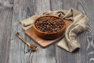 Tahta fonda kahve çekirdekleri olan ahşap bir kase.