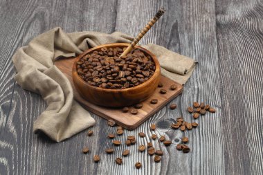 Tahta fonda kahve çekirdekleri olan ahşap bir kase.