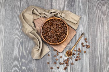 Tahta fonda kahve çekirdekleri olan ahşap bir kase.