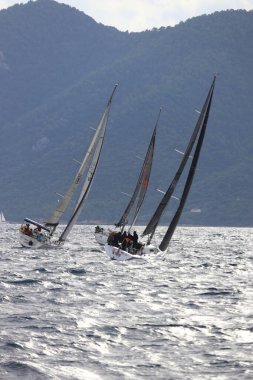 Bodrum, Hindi. 15 Aralık 2024: Yelkenliler Ege Denizi 'nin mavi sularında, ünlü tatil beldesi Bodrum' un kıyılarında rüzgarlı havada yelken açıyorlar..