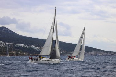 Bodrum, Hindi. 15 Aralık 2024: Yelkenliler Ege Denizi 'nin mavi sularında, ünlü tatil beldesi Bodrum' un kıyılarında rüzgarlı havada yelken açıyorlar..