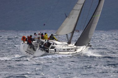 Bodrum, Hindi. 15 Aralık 2024: Yelkenliler Ege Denizi 'nin mavi sularında, ünlü tatil beldesi Bodrum' un kıyılarında rüzgarlı havada yelken açıyorlar..