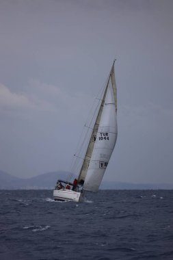 Bodrum,Turkey. 15 December 2024: Sailboats sail in windy weather in the blue waters of the Aegean Sea, on the shores of the famous holiday destination Bodrum. clipart