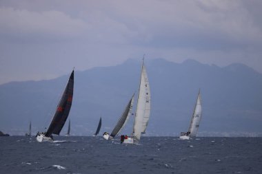 Bodrum, Hindi. 15 Aralık 2024: Yelkenliler Ege Denizi 'nin mavi sularında, ünlü tatil beldesi Bodrum' un kıyılarında rüzgarlı havada yelken açıyorlar..