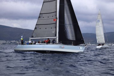 Bodrum, Hindi. 11 Ocak 2025: Yelkenliler Ege Denizi 'nin mavi sularında, ünlü tatil beldesi Bodrum' un kıyılarında rüzgarlı havada yelken açıyorlar..