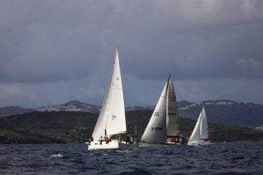 Bodrum,Turkey. 11 January 2025: Sailboats sail in windy weather in the blue waters of the Aegean Sea, on the shores of the famous holiday destination Bodrum. clipart