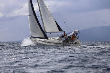 Bodrum,Turkey. 11 January 2025: Sailboats sail in windy weather in the blue waters of the Aegean Sea, on the shores of the famous holiday destination Bodrum. clipart